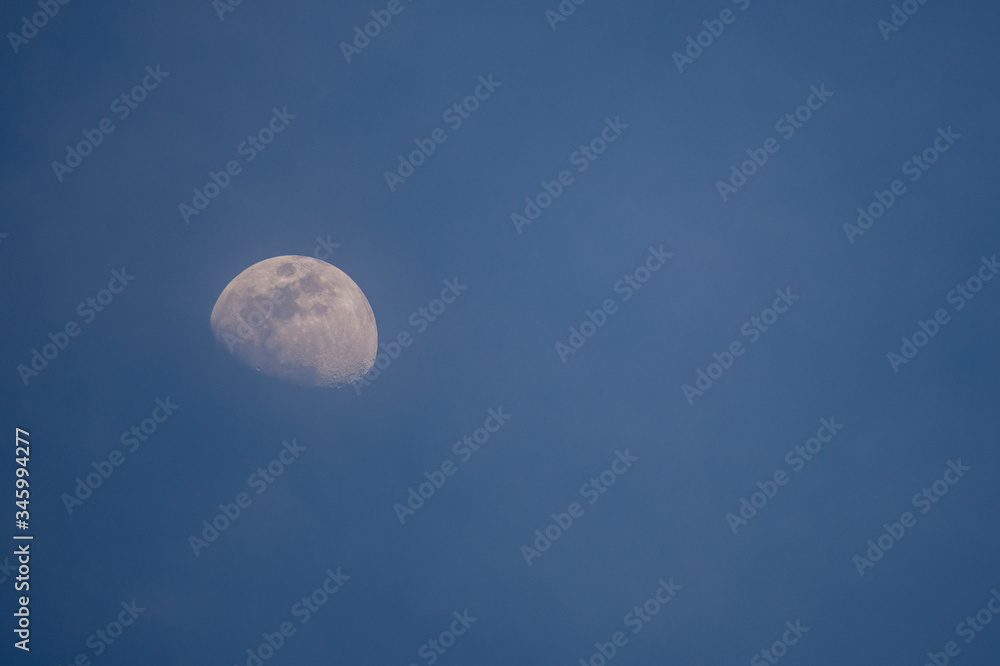 A beautiful Half moon In the daytime with Sky Blue A beautiful Half moon In the daytime with Sky Blue