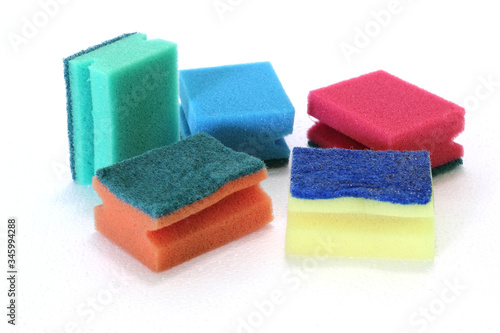 Sponges for washing dishes of different colors on a white background. Cleaning an apartment or house.