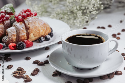 .French breakfast, great design for any purpose. Sweet food. Healthy breakfast. View from above. Aesthetic look. Raspberries, currants and blackberries. Coffee beans in bulk. Hot and aromatic coffee