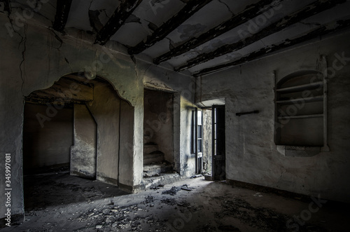 Habitaci  n sucia con puertas en la penumbra de casa de campo abandonada en ruinas. 