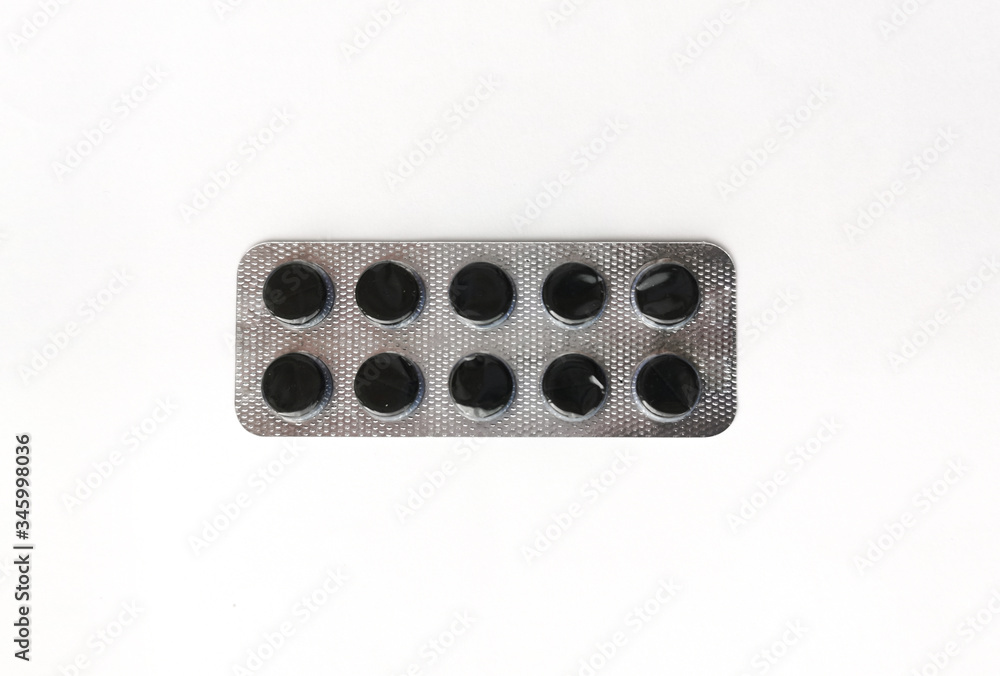 Medical pills in a pack, isolated on white. Activated charcoal, pills for cleansing the stomach. Medical pills in a pack, isolated on white. Activated charcoal, pills for cleansing the stomach.