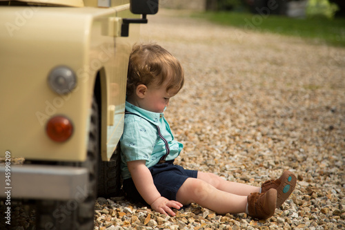 Slika na platnu Little boy sulking by toy car