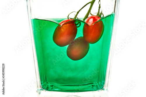 tomato in glass with green liquid