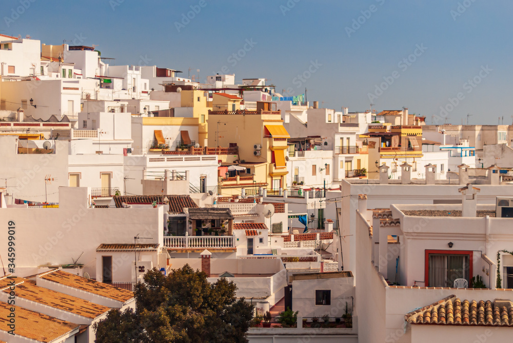 Looking across the roofs of houses and apartments in the golden sunlight at the Costa Tropical town of La Herradura, Granada, Spain