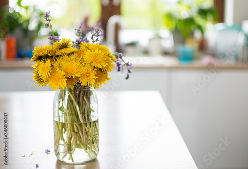 Bukiet żółtych polnych kwiatów stojący w kuchni w dziennym jasnym świetle