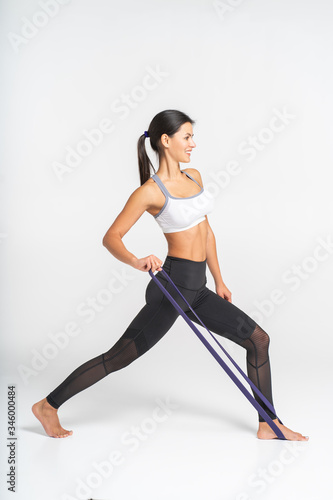 Woman doing pilates exercises with elastic