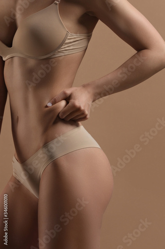Thin woman shows fold of fat