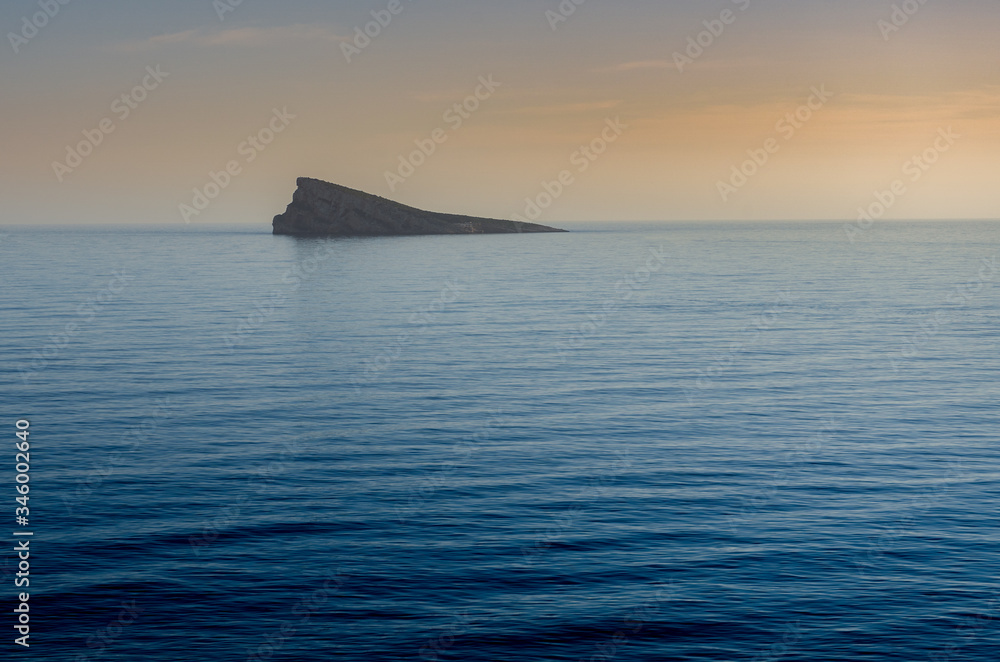 Isla en un mar en calma durante un atardecer Isla en un mar en calma durante un atardecer