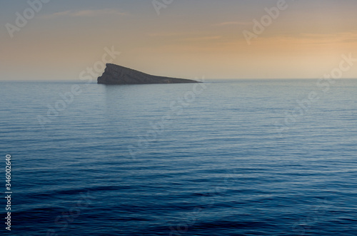 Isla en un mar en calma durante un atardecer