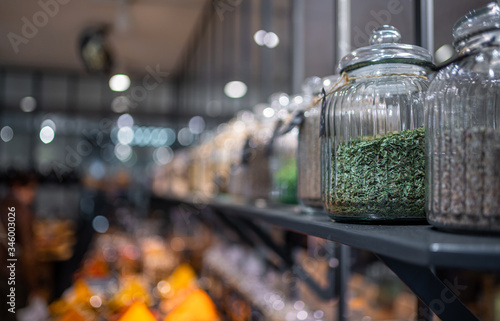 Health Food Ingredients - herbs and seeds in spice glass jars, with reflections - panorama.