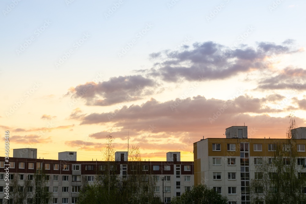 Sunrise and sunset, beautiful clouds over the meadow, hills and buildings in the town. Slovakia