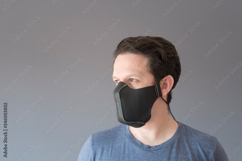 Portrait of a young man wearing a homemade synthetic leather face mask Portrait of a young man wearing a homemade synthetic leather face mask