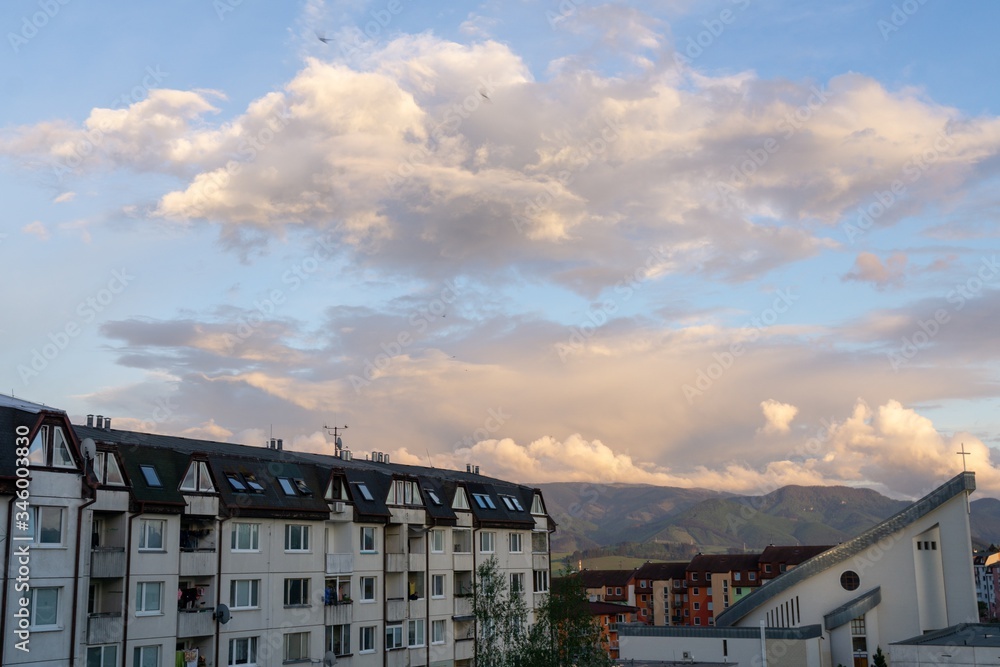 Sunrise and sunset, beautiful clouds over the meadow, hills and buildings in the town. Slovakia