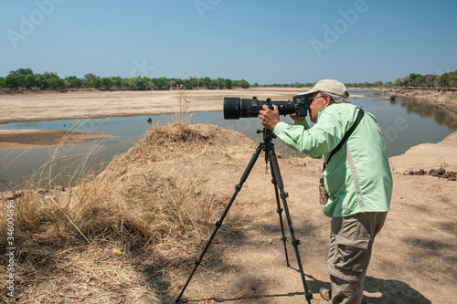 Photography A photographer shooting in a National Park in Africa with a big telephoto lens a