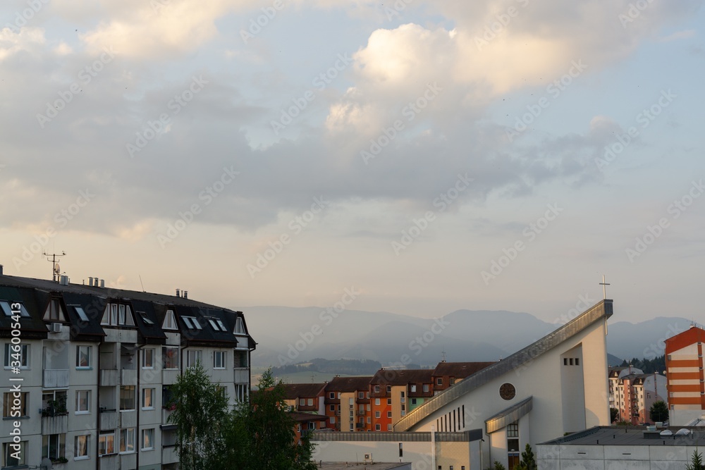 Sunrise and sunset, beautiful clouds over the meadow, hills and buildings in the town. Slovakia