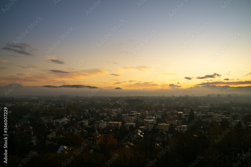Sunrise and sunset, beautiful clouds over the meadow, hills and buildings in the town. Slovakia Sunrise and sunset, beautiful clouds over the meadow, hills and buildings in the town. Slovakia