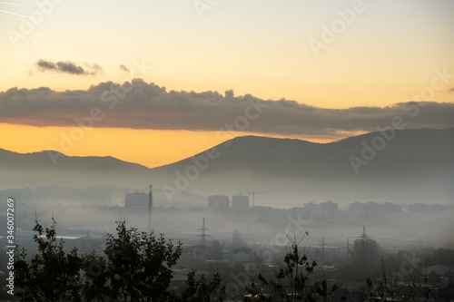 Fototapeta Naklejka Na Ścianę i Meble -  Sunrise and sunset, beautiful clouds over the meadow, hills and buildings in the town. Slovakia