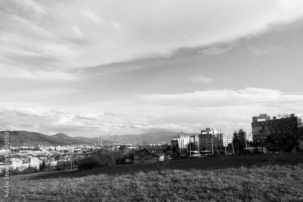 Fototapeta premium Sunrise and sunset, beautiful clouds over the meadow, hills and buildings in the town. Slovakia