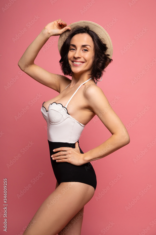 © My Ocean studio - Portrait of a gorgeous trendy fit woman in swimwear while she enjoying rest with sunlight isolated over pink background. Travel, tourism, journey, trip, tour, summer concept © My Ocean studio - Portrait of a gorgeous trendy fit woman in swimwear while she enjoying rest with sunlight isolated over pink background. Travel, tourism, journey, trip, tour, summer concept