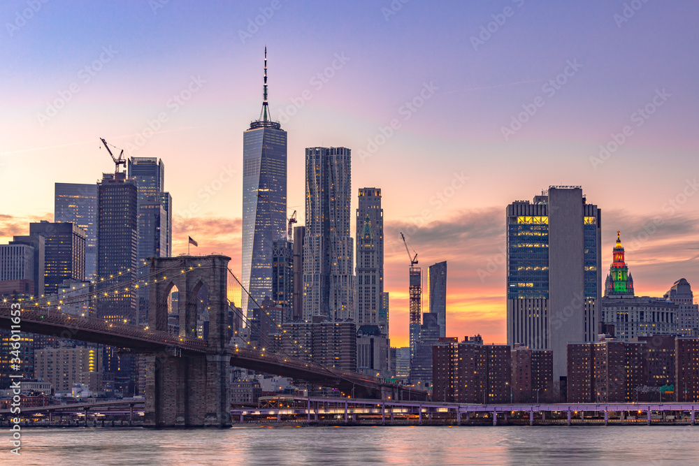 Obraz premium Zachód słońca na Manhattanie. Wiele budynków biznesowych w kolejce. Światło miasta włącza. Kolorowe niebo jest bardzo niesamowite. punkt widok z Dumbo Brooklyn. Selektywna ostrość.