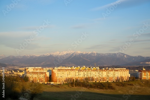 Sunrise and sunset, beautiful clouds over the meadow, hills and buildings in the town. Slovakia