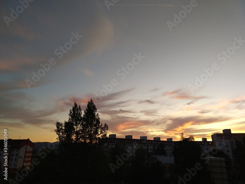 Sunrise and sunset, beautiful clouds over the meadow, hills and buildings in the town. Slovakia