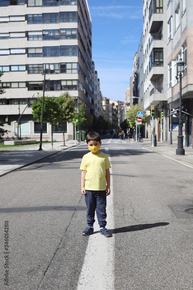 niño con mascarilla en medio de la carretera durante la pandemia del coronavirus