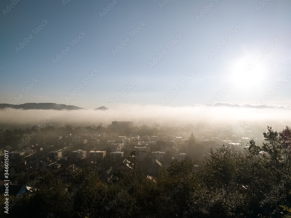 Obraz premium Sunrise and sunset, beautiful clouds over the meadow, hills and buildings in the town. Slovakia