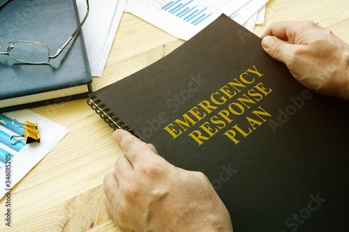 Man open disaster and emergency response plan for reading. photo