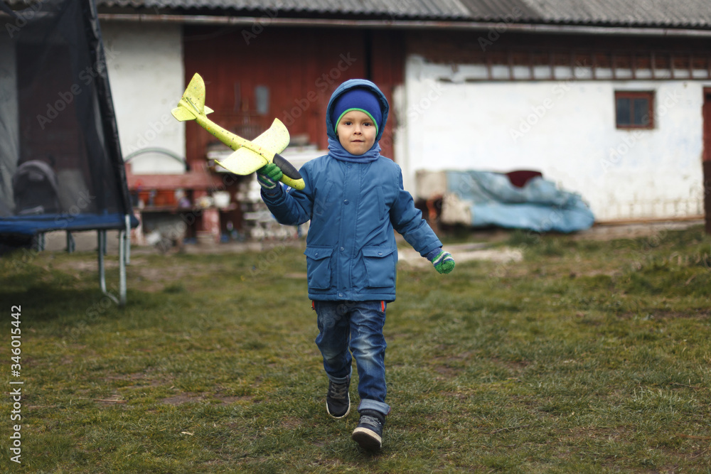Little boy with toy airplane playing in spring outdoors image