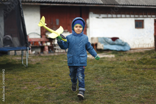 Wallpaper Mural Little boy with toy airplane playing in spring outdoors image Torontodigital.ca