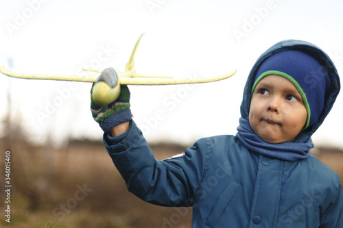 Wallpaper Mural Seriously kid playing with toy airplane against white summer sky background. Torontodigital.ca