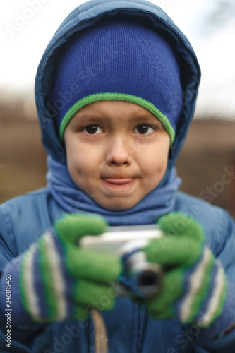 Wallpaper Mural Portrait of the caucasian cute little cheerful child boy hold photo camera. Compact photographer doing taking the picture. Torontodigital.ca