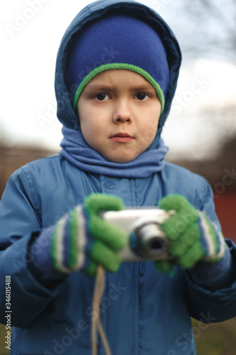 Wallpaper Mural Portrait of the caucasian cute little cheerful child boy hold photo camera. Compact photographer doing taking the picture. Torontodigital.ca