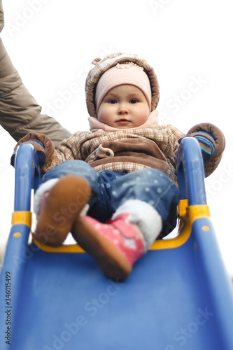 Wallpaper Mural A happy child sits on a children's slide and smiles in a stylish brown jacket and hat in autumn. Fashion and style for children. Torontodigital.ca