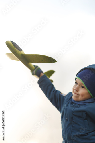 Wallpaper Mural Seriously kid playing with toy airplane against white summer sky background. Torontodigital.ca