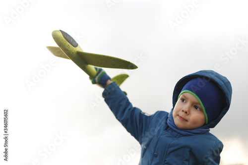 Wallpaper Mural Seriously kid playing with toy airplane against white summer sky background. Torontodigital.ca