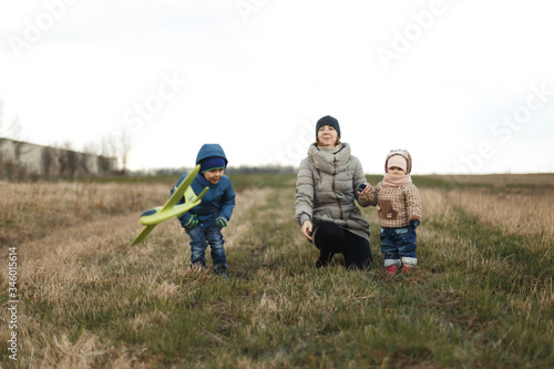 Wallpaper Mural Young mother with two children, a little girl and a boy playing in the autumn field. Autumn family in the Park playing with toy airplane. Torontodigital.ca