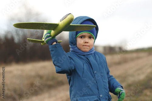 Wallpaper Mural Seriously kid playing with toy airplane against white summer sky background. Torontodigital.ca
