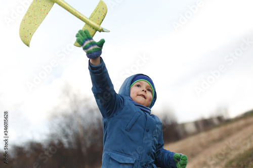 Wallpaper Mural Boy playing with toy glider in field on spring day Torontodigital.ca