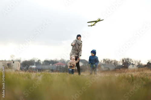 Wallpaper Mural Young mother with two children, a little girl and a boy playing in the autumn field. Autumn family in the Park playing with toy airplane. Torontodigital.ca