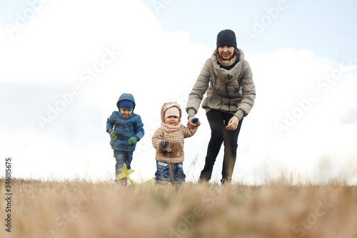 Wallpaper Mural Young mother with two children, a little girl and a boy playing in the autumn field. Autumn family in the Park playing with toy airplane. Torontodigital.ca