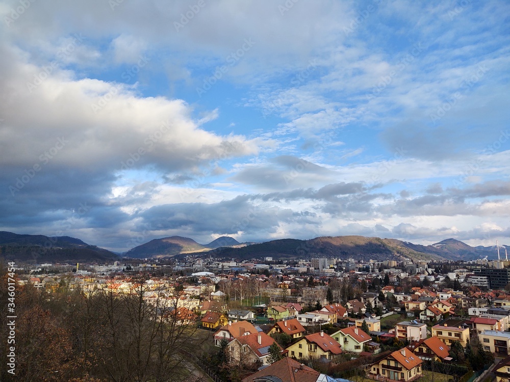 Sunrise and sunset, beautiful clouds over the meadow, hills and buildings in the town. Slovakia