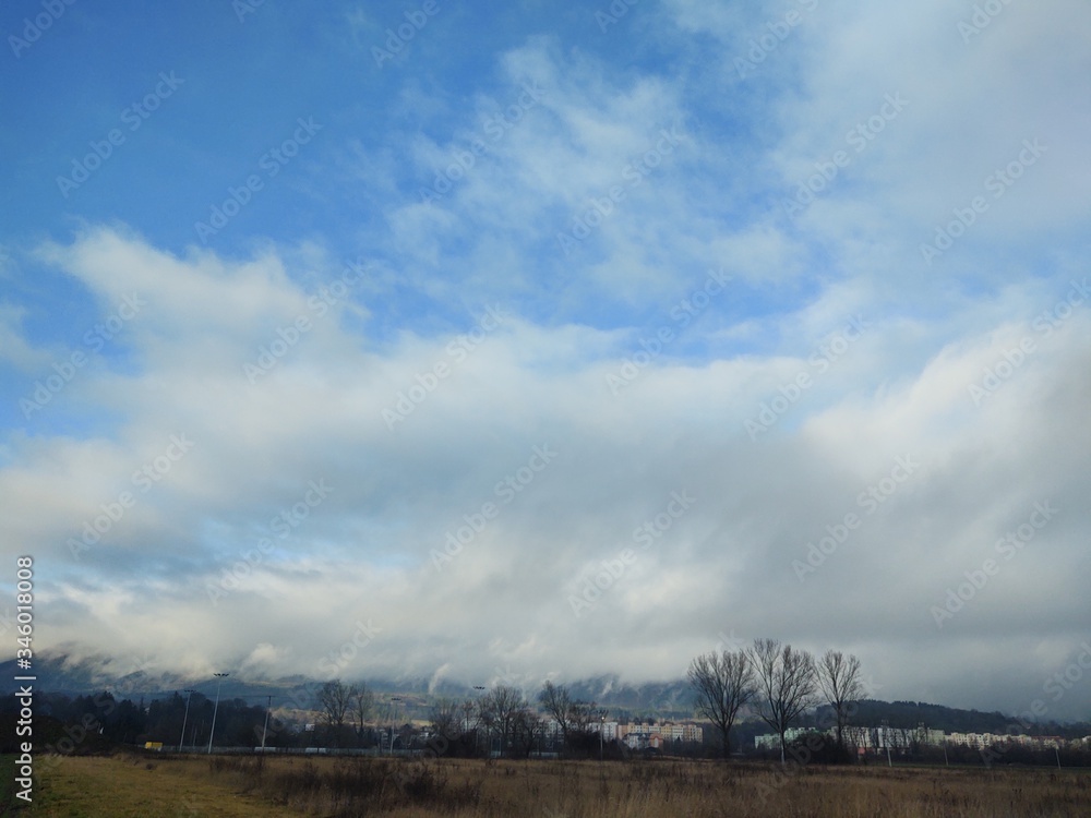Sunrise and sunset, beautiful clouds over the meadow, hills and buildings in the town. Slovakia Sunrise and sunset, beautiful clouds over the meadow, hills and buildings in the town. Slovakia