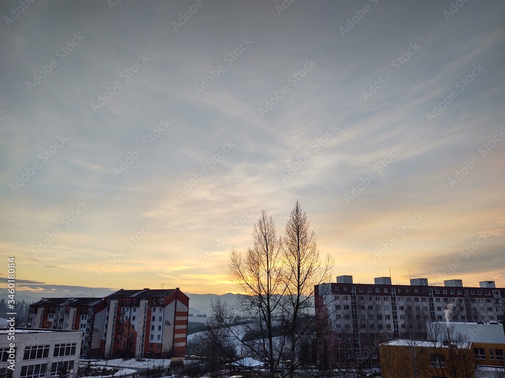 Sunrise and sunset, beautiful clouds over the meadow, hills and buildings in the town. Slovakia Sunrise and sunset, beautiful clouds over the meadow, hills and buildings in the town. Slovakia