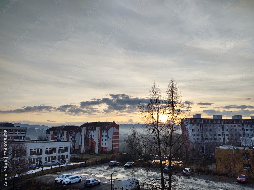 Sunrise and sunset, beautiful clouds over the meadow, hills and buildings in the town. Slovakia