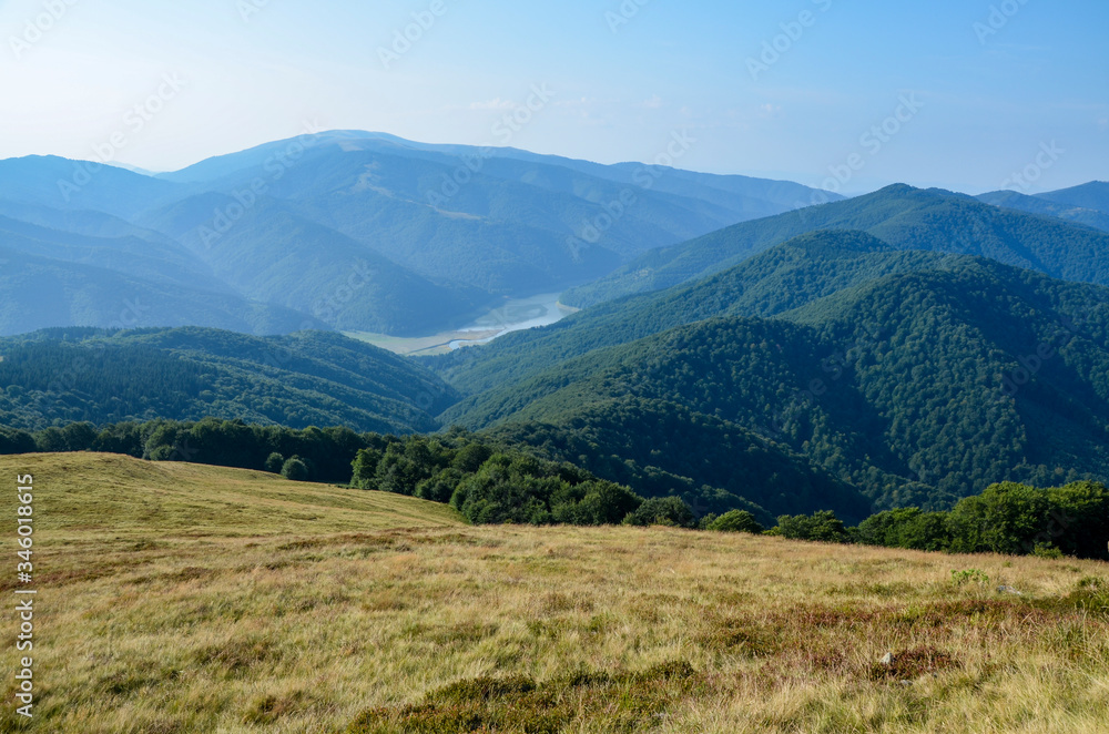 Carpathian mountains scenery with hills, water reservoir and blue sky with clouds on the river Tereblya near the Protiven village, Ukraine
