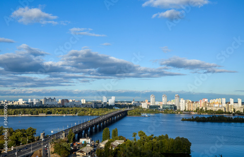 View of Paton Bridge and and new residential district on the Left Bank of the Dnipro river on sunny day in Kyiv, Ukraine