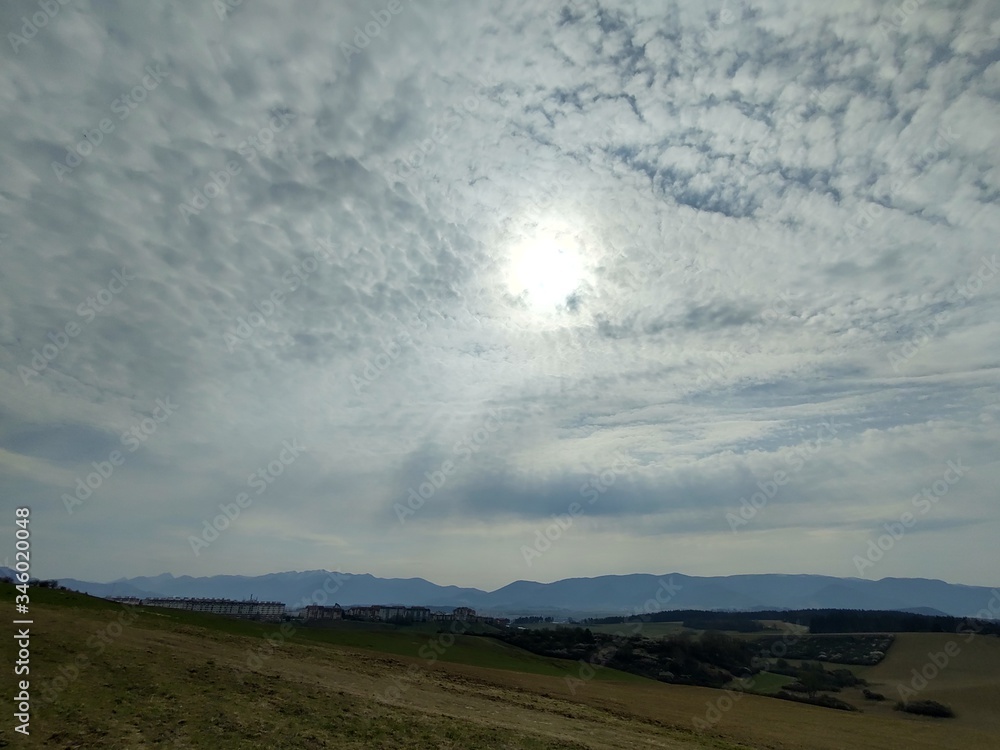Sunrise and sunset, beautiful clouds over the meadow, hills and buildings in the town. Slovakia Sunrise and sunset, beautiful clouds over the meadow, hills and buildings in the town. Slovakia