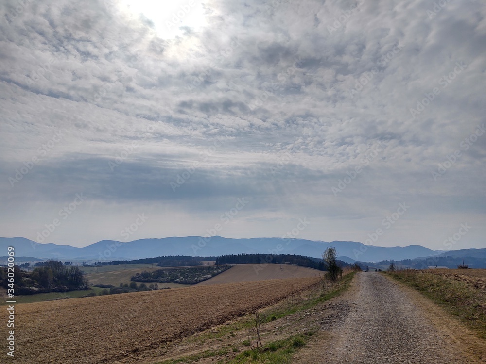 Sunrise and sunset, beautiful clouds over the meadow, hills and buildings in the town. Slovakia